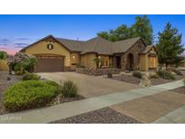 Charming single-story home featuring a stone facade, well-manicured landscaping, and a paver driveway at 7587 W Quail Ave, Glendale, AZ 85308
