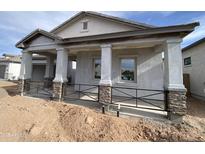 New construction home showing inviting covered front porch with stone column accents and metal railing at 1171 E Peach Tree Dr, Chandler, AZ 85249