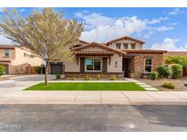 Beautiful two-story home featuring a stone facade, manicured lawn, and tasteful landscaping at 13367 W Jesse Red Dr, Peoria, AZ 85383