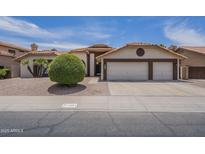 Charming single-story home featuring a three-car garage and desert landscaping at 1461 W Tara Dr, Gilbert, AZ 85233