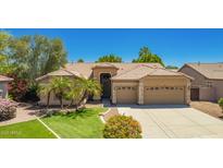 Charming single-story home with a three-car garage, lush green lawn, and desert landscaping at 1811 S Brentwood Pl, Chandler, AZ 85286
