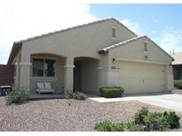 Charming single-story home featuring a two-car garage and covered porch with sitting bench at 18599 W Illini St, Goodyear, AZ 85338