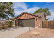 Charming single-Gathering home with brick accents, two-car garage, and well-maintained front yard at 40427 N Orkney Way, San Tan Valley, AZ 85140