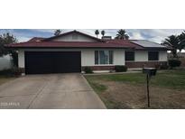 Charming single-story home with a red tile roof, well-manicured lawn, and solar panels at 4353 W Mescal St, Glendale, AZ 85304