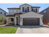 Charming two-story home boasts a well-manicured lawn and a welcoming stone-accented porch at 4771 E Meadow Land Dr, San Tan Valley, AZ 85140