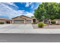 Charming single-story home featuring a three-car garage, desert landscaping, and mature shade tree at 8738 W Runion Dr, Peoria, AZ 85382
