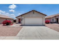 Home with a driveway and two-car garage complemented by lovely desert landscaping and an inviting entrance at 12233 W Aster Dr, El Mirage, AZ 85335