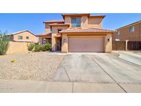 Two-story home featuring a spacious driveway and low-maintenance landscaping under a clear blue sky at 1556 E Gabrilla Dr, Casa Grande, AZ 85122