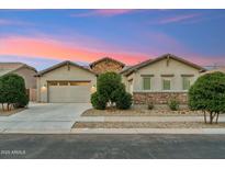 Charming single-story home featuring a stone facade, desert landscaping, and a two-car garage in a serene neighborhood at 16852 W Creedance Blvd, Surprise, AZ 85387