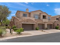 Beautiful townhome featuring a stone facade, private balconies, and attached garages in a well-maintained community at 19475 N Grayhawk Dr # 2151, Scottsdale, AZ 85255
