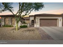 Charming single-story home featuring manicured landscaping, a brick-paved walkway, and an attached garage at 27007 N 20Th Ln, Phoenix, AZ 85085