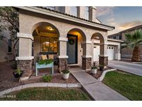 Charming front porch with stone columns and covered entryway, creating a welcoming facade at 3773 E Stampede Dr, Gilbert, AZ 85297