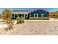 Charming blue home featuring well-maintained landscaping, solar panels, and a gravel yard for low maintenance at 5321 N 196Th Ave, Litchfield Park, AZ 85340