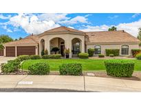 Beautiful single-story home with well-maintained lawn and arched entryway, showcasing classic design at 8603 E Aster Dr, Scottsdale, AZ 85260