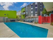 Inviting pool area with lounge chairs surrounded by colorful modern buildings and clear blue sky at 1111 W University Dr # 3016, Tempe, AZ 85281
