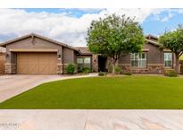 Charming single-story home with a well-manicured front yard, complemented by desert landscaping and a neutral color scheme at 12834 W Forest Pleasant Pl, Peoria, AZ 85383