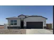 Charming single-story home featuring a gray two-car garage and modern architectural details against a clear blue sky at 1300 W Bealey Ave, Coolidge, AZ 85128