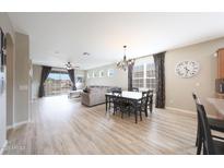 Open concept living room features wood-look floors, neutral paint, and abundant natural light at 16039 W Pima St, Goodyear, AZ 85338