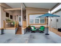 Inviting porch with comfortable seating and a vibrant blue umbrella at 17200 W Bell Rd # 1015, Surprise, AZ 85374