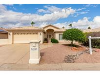 Inviting beige home featuring a two-car garage, well-maintained landscaping, and a charming tile roof at 24907 S Lakestar Dr, Sun Lakes, AZ 85248