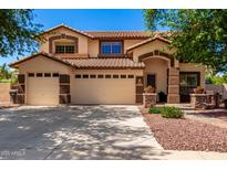 Inviting two-story home with a three-car garage and well-maintained desert landscaping at 2648 E Teakwood Pl, Chandler, AZ 85249