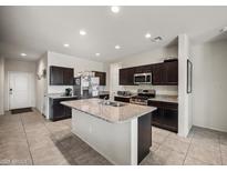 The kitchen features a large island, stainless steel appliances, and plenty of cabinet space for storage at 30963 W Columbus Ave, Buckeye, AZ 85396