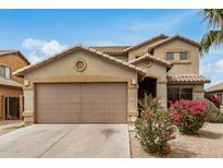 Charming two-story home with a two car garage and landscaped front yard with colorful shrubs at 5220 W Desert Ln, Laveen, AZ 85339