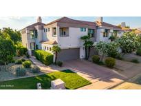 Beautiful townhome with a two-car garage, lush landscaping, and a well-maintained lawn at 7222 E Gainey Ranch Rd # 140, Scottsdale, AZ 85258
