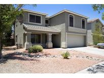 Two-story home showcasing desert landscaping, a covered porch, and neutral earthtone colors at 8514 S 49Th Dr, Laveen, AZ 85339