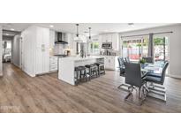 Modern kitchen features white cabinetry, an island with seating, and stainless steel appliances at 8714 E Plaza Ave, Scottsdale, AZ 85250