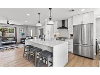 Bright kitchen with an island featuring barstool seating and stainless steel appliances at 8714 E Plaza Ave, Scottsdale, AZ 85250