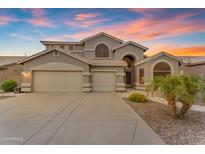 Elegant two-story home featuring a three-car garage and desert landscaping at 9702 E Naranja Ave, Mesa, AZ 85209