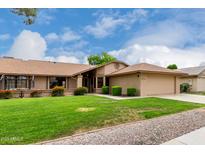 Well-maintained home featuring a lush green lawn, colorful landscaping, and a neatly manicured garden at 13015 W Blue Sky Dr, Sun City West, AZ 85375