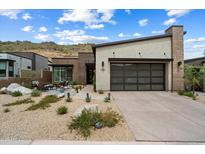 Charming single-story home featuring desert landscaping, a brick chimney, and a modern garage door at 14551 N Adero Canyon Dr, Fountain Hills, AZ 85268