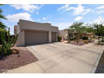 Charming home with a three-car garage, beautiful desert landscaping, and a spacious driveway at 2105 E San Carlos Pl, Chandler, AZ 85249
