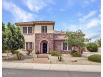 Charming two-story home featuring a stone and stucco facade, landscaped yard, and a welcoming arched entryway at 5812 W Spur Dr, Phoenix, AZ 85083