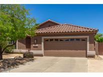 Charming single-story home with a two-car garage, desert landscaping, and a terracotta-tiled roof at 7456 W Irma Ln, Glendale, AZ 85308