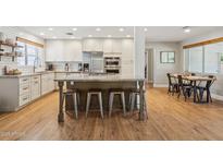 Bright kitchen with white cabinetry, stainless steel appliances, large island with seating, and stylish tile backsplash at 7607 N 17Th Ave, Phoenix, AZ 85021