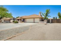 Home exterior showcasing a well-maintained house with a two-car garage and desert landscaping at 13650 N 70Th Dr, Peoria, AZ 85381
