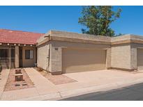 Beige garage door in a neutral colored home with a red tile roof, desert landscaping, and a private driveway at 1506 N Oak St, Tempe, AZ 85288