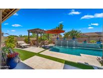 Beautiful pool featuring a pergola, orange umbrella, a deck-level fountain and ample outdoor seating under a blue sky at 19877 S 185Th Way, Queen Creek, AZ 85142