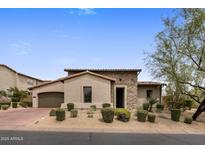 Charming single-story home featuring a stone facade, desert landscaping, and a welcoming entrance at 20055 N 96Th Way, Scottsdale, AZ 85255