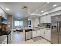 Modern kitchen with stainless steel appliances, gray backsplash, and an island sink at 2020 W Union Hills Dr # 110, Phoenix, AZ 85027