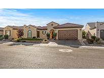Charming single-story home featuring a desert-landscaped front yard, a clay tile roof, and an attached two-car garage at 25971 W Taro Dr, Buckeye, AZ 85396