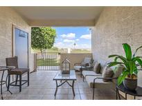 Relaxing covered patio with cushioned seating and a view of the manicured lawn at 2801 N Litchfield Rd # 65, Goodyear, AZ 85395