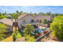 Aerial view of a home's backyard featuring a pool, spa, covered patio, putting green, and desert landscaping at 6847 S 27Th Pl, Phoenix, AZ 85042