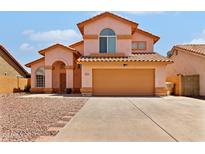 Two-story home featuring a tile roof, two-car garage, and desert landscaping at 7767 W Sierra Vista Dr, Glendale, AZ 85303