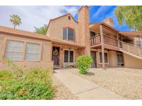 Charming townhome featuring a brick chimney, colorful landscaping, and a cozy, inviting entrance at 8111 W Wacker Rd # 62, Peoria, AZ 85381