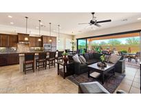 Open-concept living room with modern furniture, island seating, and seamless transition to the outdoor patio at 8544 E Kael St, Mesa, AZ 85207