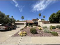 Attractive single-story home features desert landscaping, and a tiled roof, complete with an attached two-car garage at 9916 E Topaz Dr, Scottsdale, AZ 85258